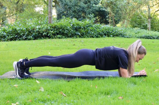 Lianne planking in het gras in een park